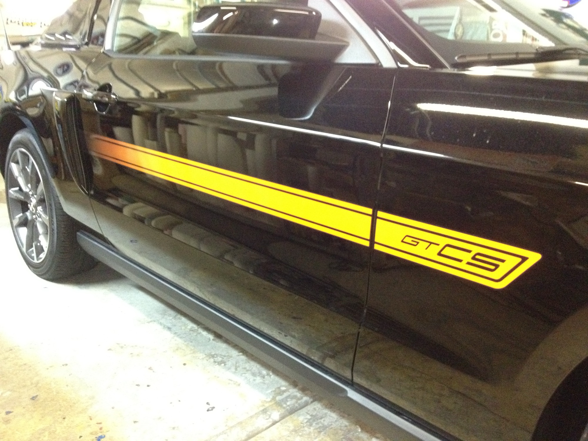 Precise vinyl side stripe and GT/CS graphics on a black Mustang